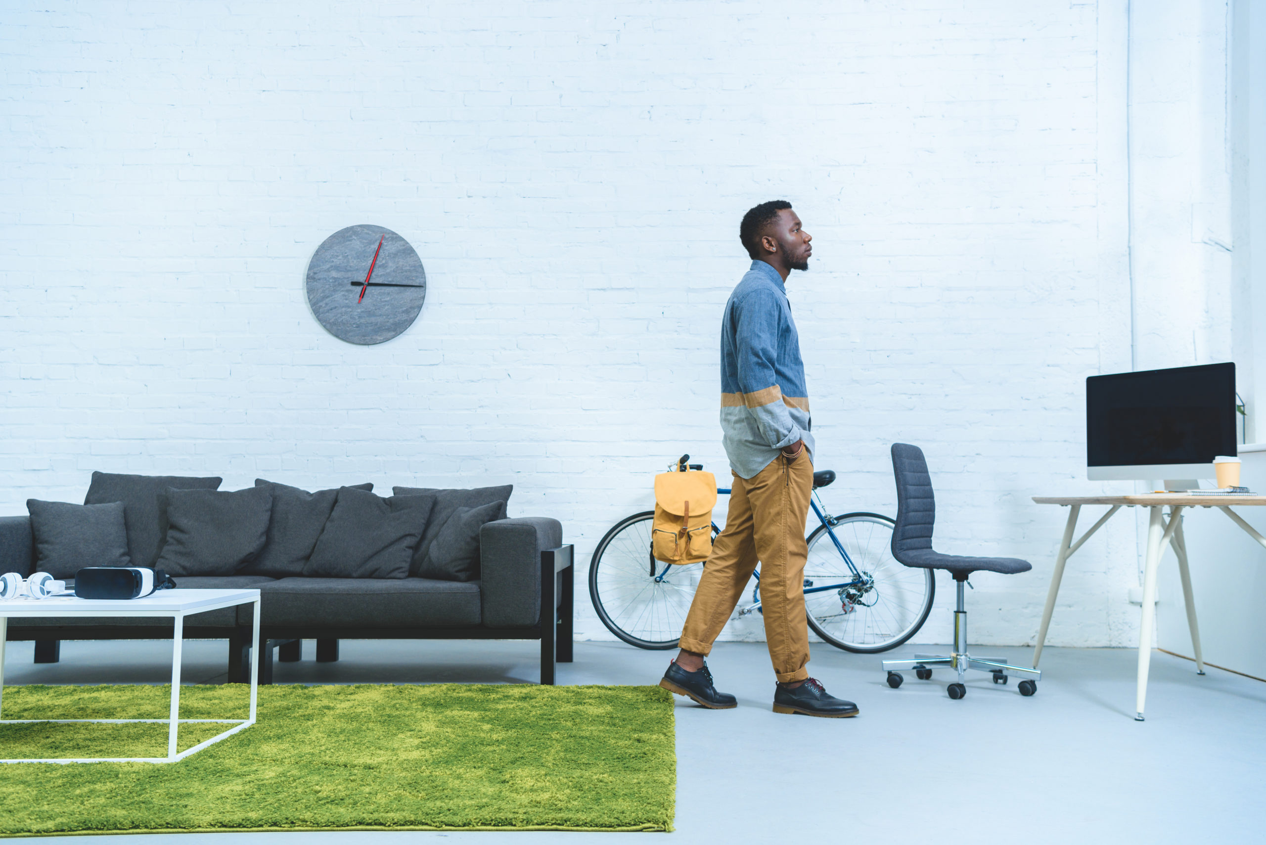 Man walking past coffee table with VR gear